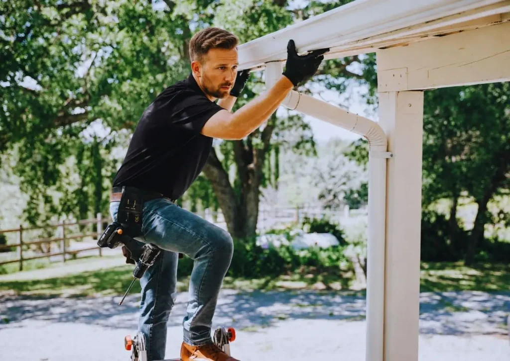 A man repairing a rain gutter in denver metro area